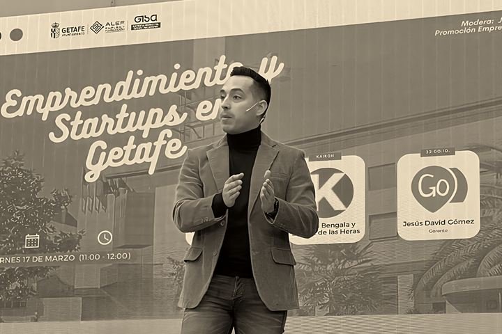 Rubén Bengala en el escenario de la jornada Emprendimiento y Startups en Getafe, con el logotipo de Kairon en la pantalla